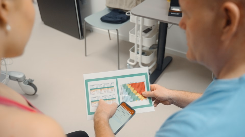 Patient hos Naya får præsenteret en graf med data omkring hende af en ansat ved Naya